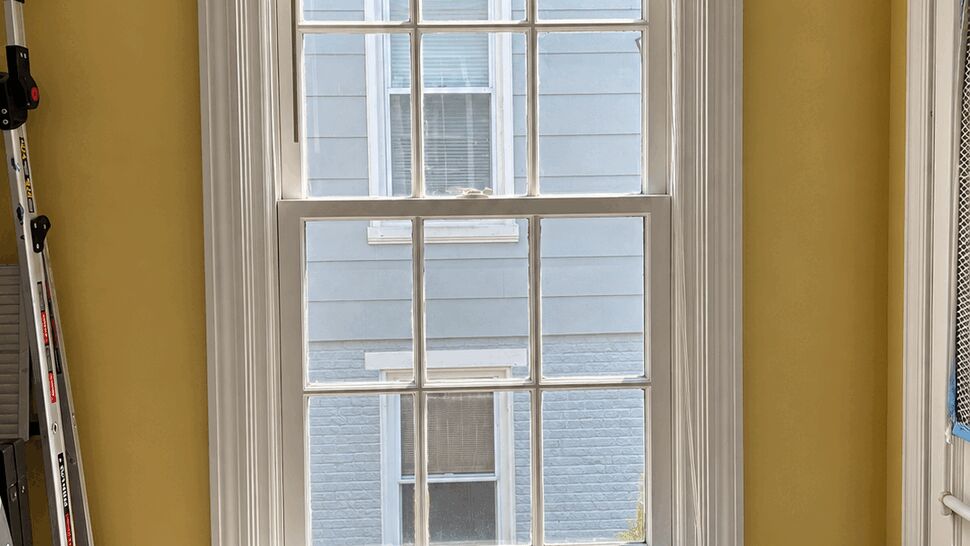 Double-hung Window Interior Trim | Tycos Roofing And Siding Inc Interior double-hung window with blinds, white trim and yellow walls