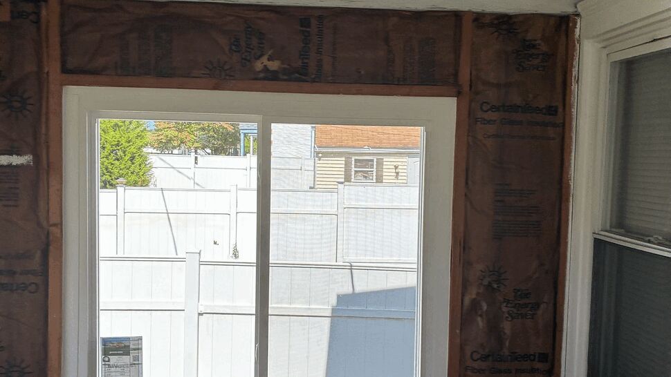 Interior view of new window surrounded by insulation and exposed studs