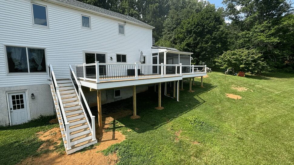 Expansive raised deck with stairs | Tycos Roofing And Siding Inc Wide view of raised deck with stairs and white siding
