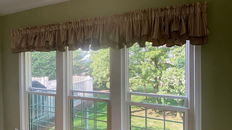 Bright Living Room Triple Windows | Tycos Roofing And Siding Inc Bright living room with triple windows, hardwood floor and green walls.