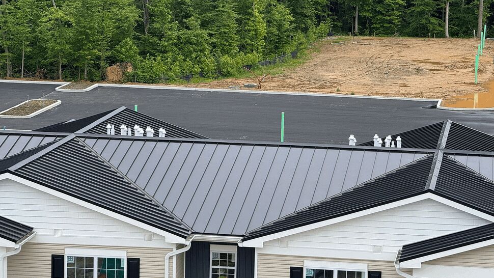 Aerial view of black standing seam metal roof and white gutters