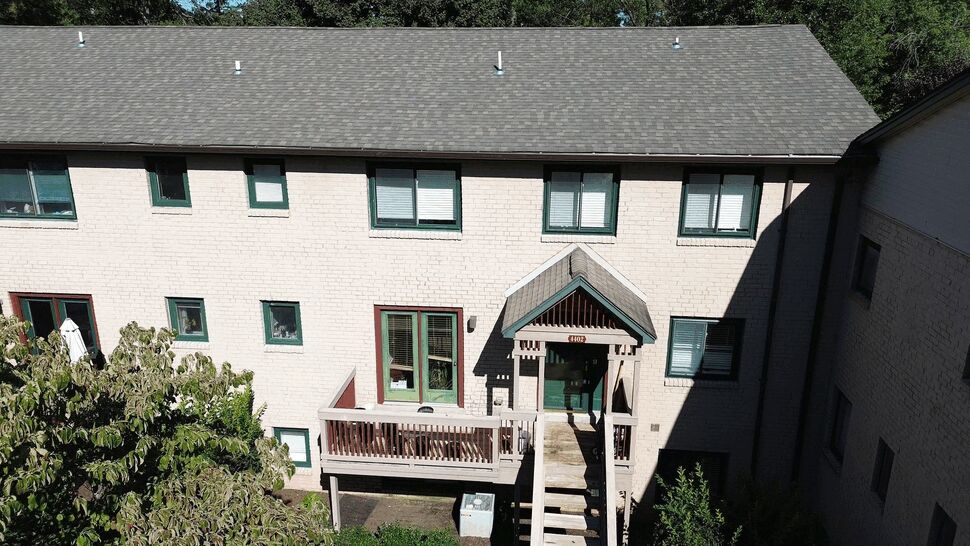 Multi-unit roof and entrance view | Tycos Roofing And Siding Inc Multi-unit building facade showing roofline, entrance canopy and second-floor deck.