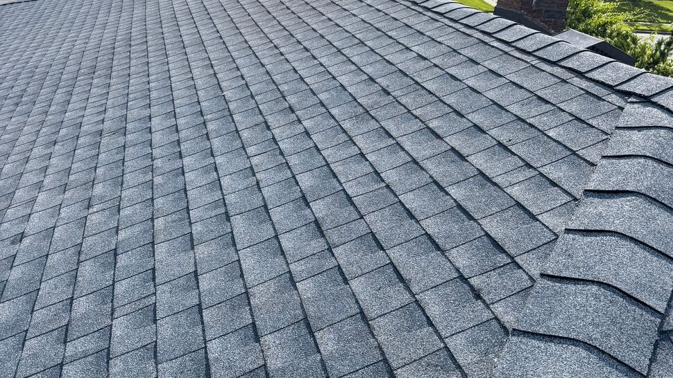 Close-up of gray asphalt shingle roof and ridge line.