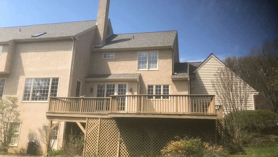 Raised wooden deck with lattice skirting and backyard view