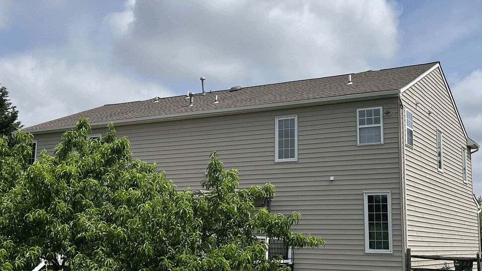 Rear Exterior with Gutters | Tycos Roofing And Siding Inc Rear exterior view with roofline, gutters, and beige siding