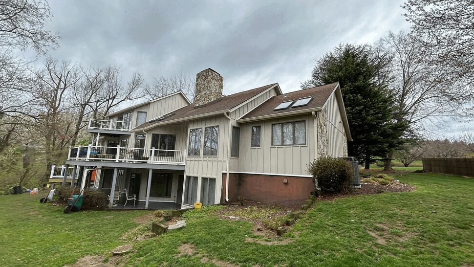 Rear of house showing multi-level decks, skylights, and sloped roof