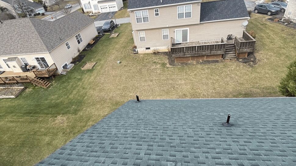 Aerial view of shingle roof overlooking backyards and neighboring homes.