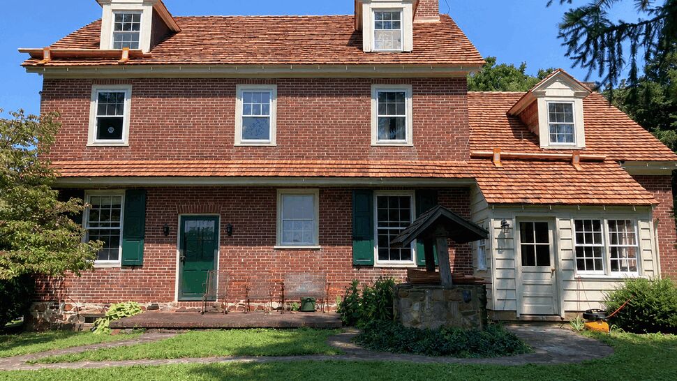 Sunroom Siding and Gutters | Tycos Roofing And Siding Inc Back of house with white sunroom, cedar roof and copper gutters visible