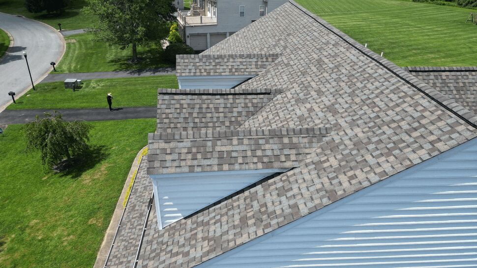 High-angle shot of multiple roof gables, ridges and a visible gutter along the eave.