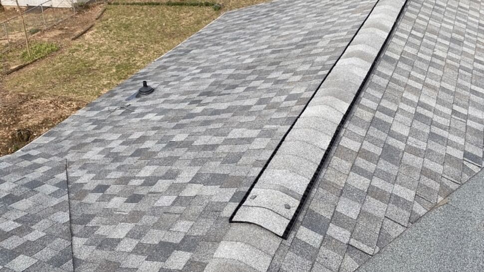 Close view of ridge vent and patterned asphalt shingles on pitched roof