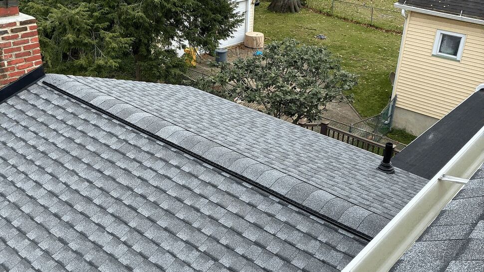 Roof and Gutter Overhead View | Tycos Roofing And Siding Inc Gray shingle roof with white gutters overlooking a residential backyard