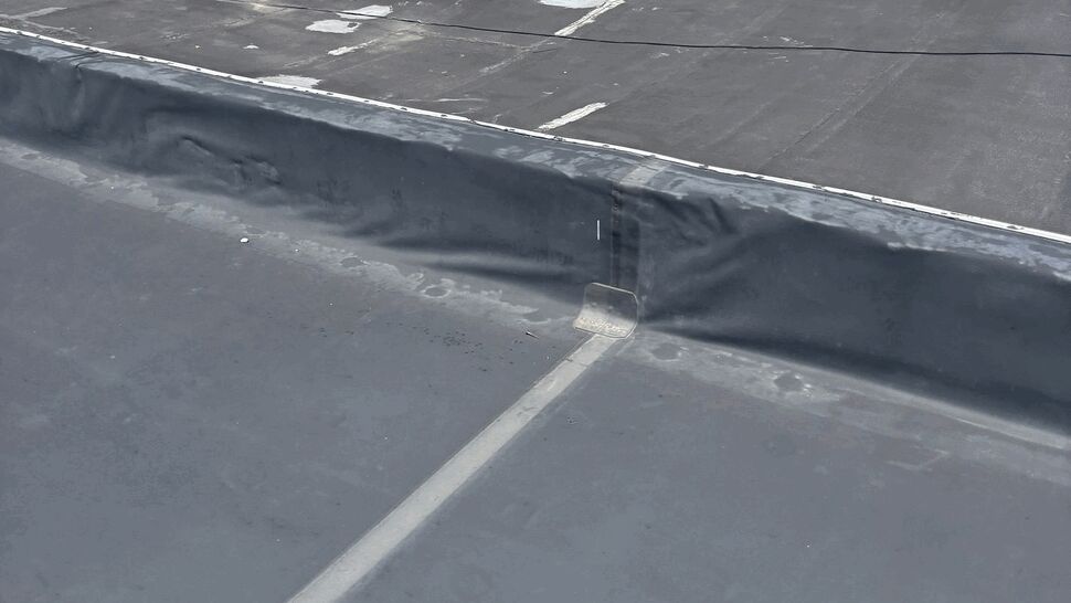 Close-up of sealed seams and flashing on a flat roof membrane.