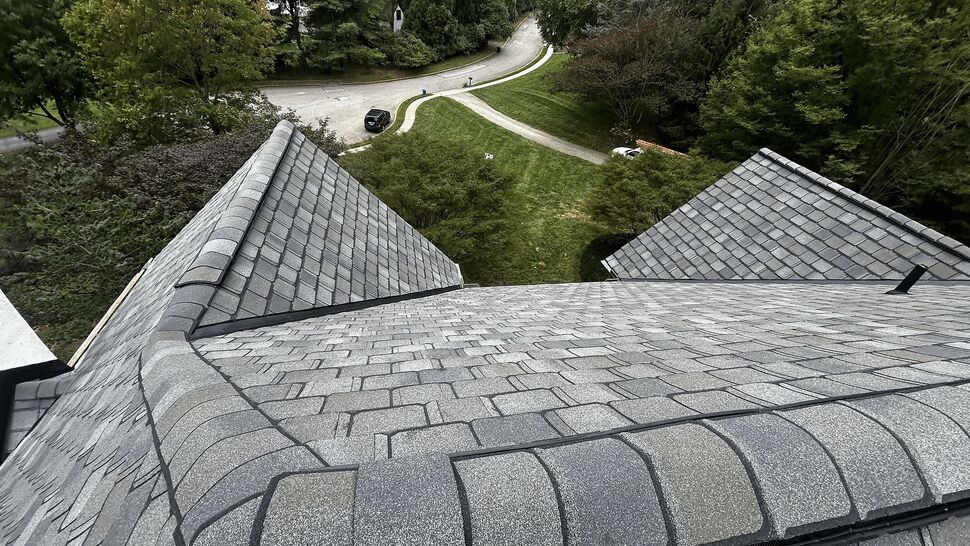 View from roof ridge overlooking yard and neighborhood with shingled roofs