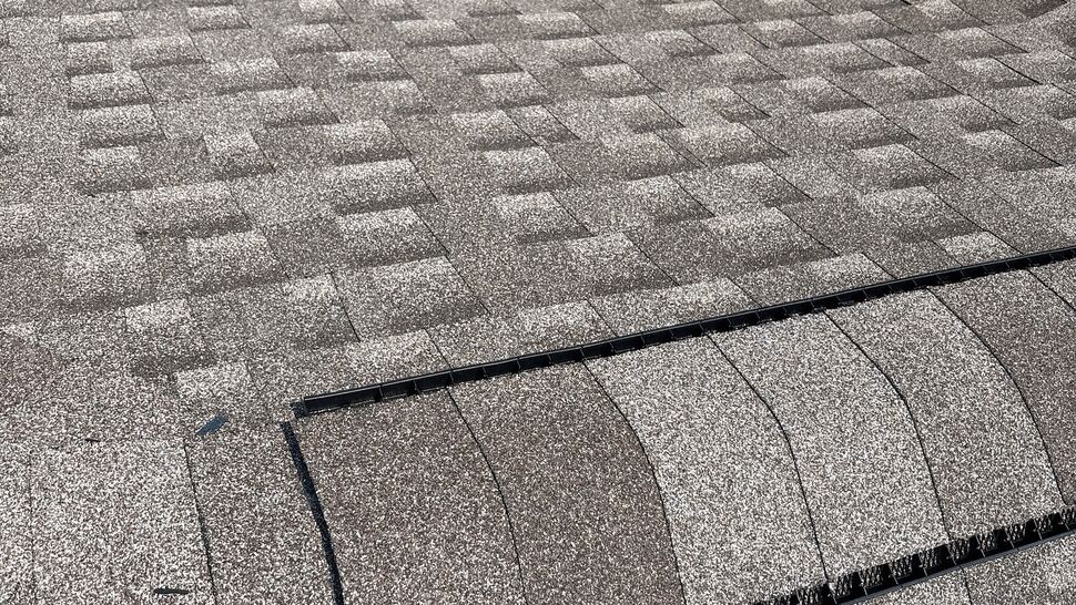 Ridge Vent Detail on Shingled Roof | Tycos Roofing And Siding Inc Close-up of shingled ridge vent near a dormer and siding