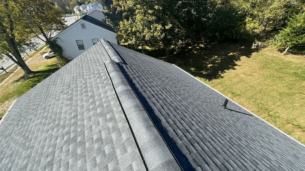 Aerial view of shingled roof ridge with ridge vent and vent pipe