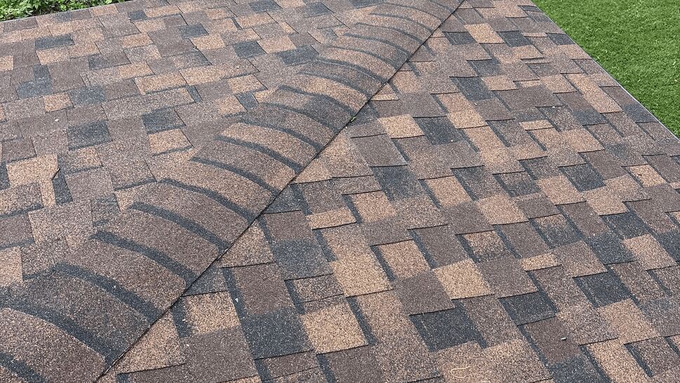 Asphalt shingle ridge with Tycos company truck parked on the street below