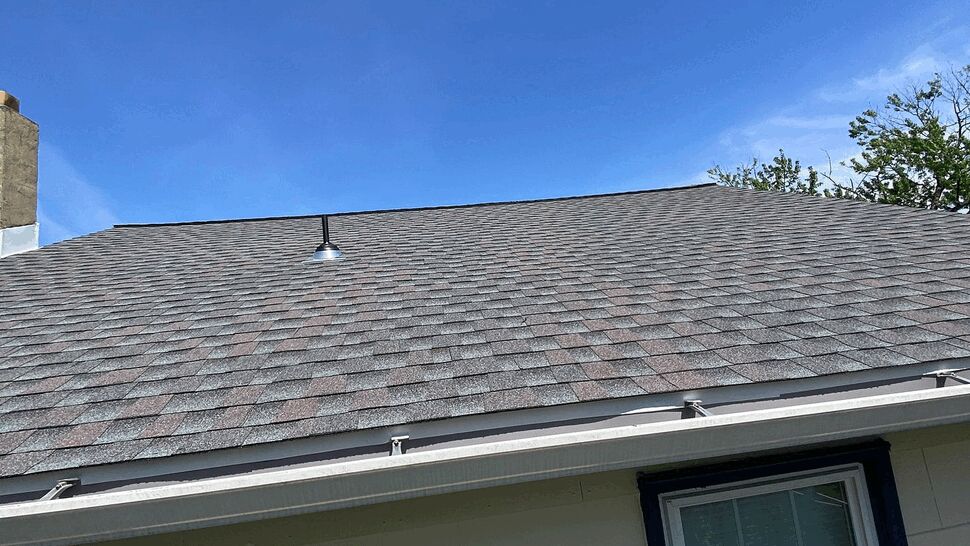 Roof, Siding, and Window Detail | Tycos Roofing And Siding Inc Close view of gray roof shingles, light siding, and a framed window.