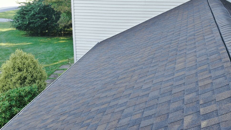 Close angled view of shingle pattern across a roof slope with ridge vent