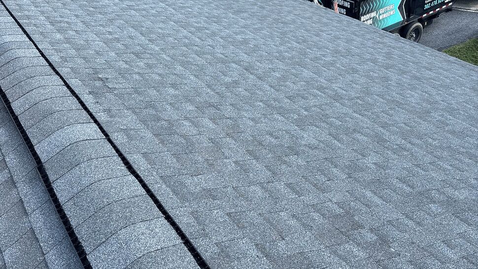 Roof view with Tycos truck below | Tycos Roofing And Siding Inc Shingled roof view looking toward street with Tycos truck parked below