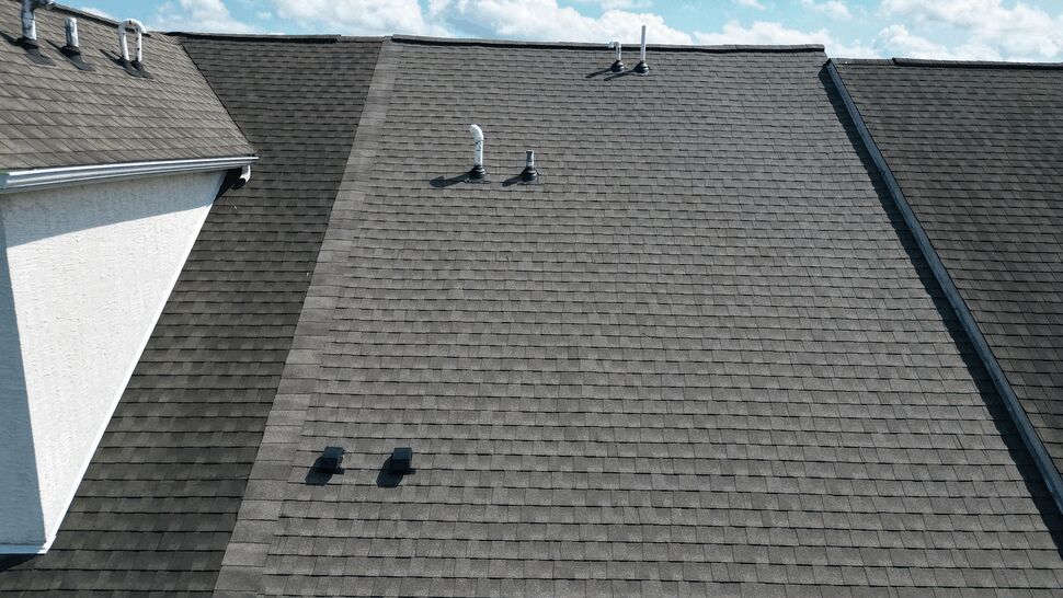 Shingle field with vents and gutter along the roof edge