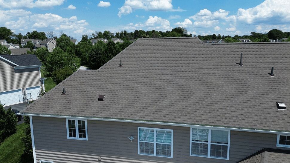 Wide top-down view of shingled roof with vents and clean roofline
