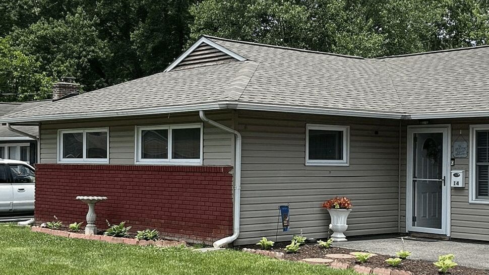 Side angle of house showing gutters, downspout, siding and roof
