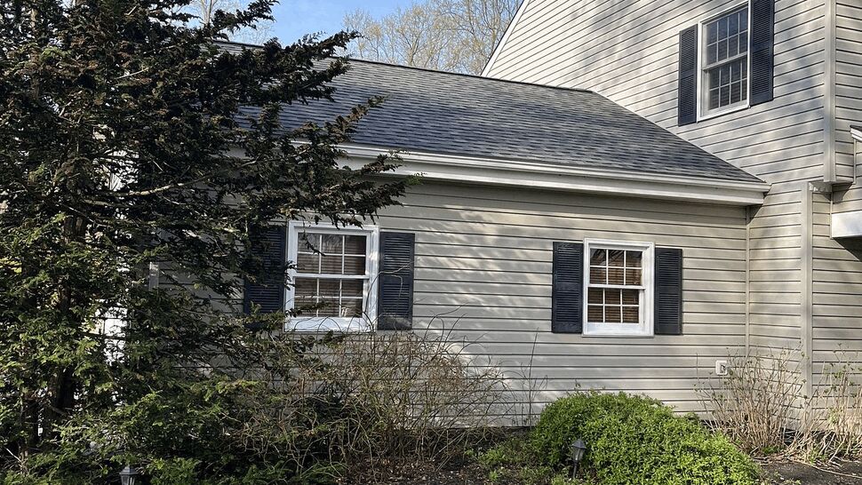 Side elevation of a single-story garage addition with windows and matching beige siding.