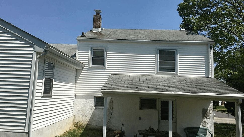 Side view showing roof, chimney and gutter system on a two-story home