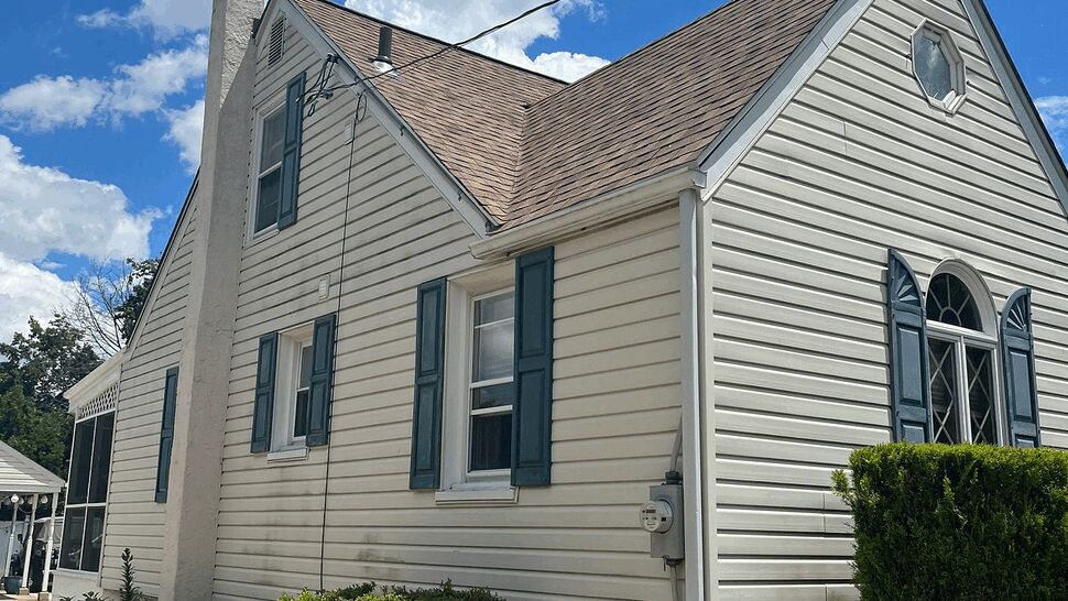 Side elevation showing vinyl siding, blue shutters, gutters and windows