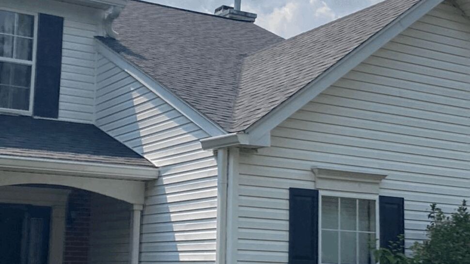Close-up of white vinyl siding, window and a white gutter on the house side.