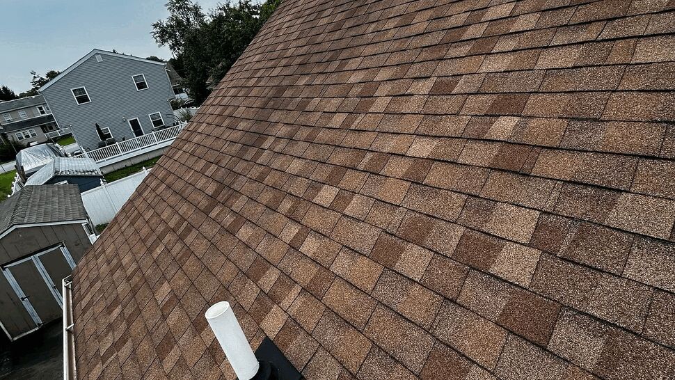 Sloped asphalt shingle roof with vent stack and visible gutter along the eave