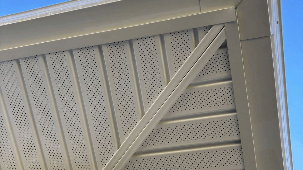 Soffit, fascia and gutter corner | Tycos Roofing And Siding Inc Close-up of perforated soffit, fascia and corner gutter