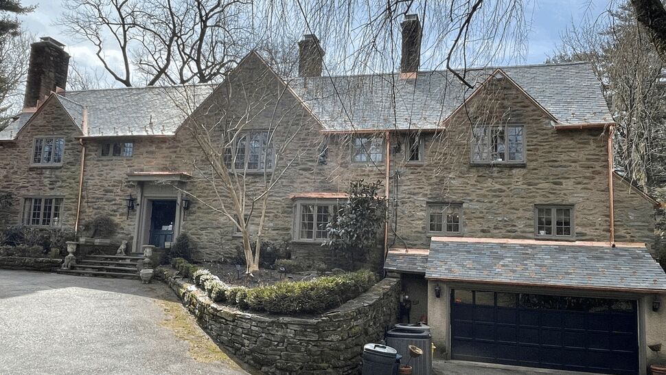 Large stone house with a slate roof and copper gutters