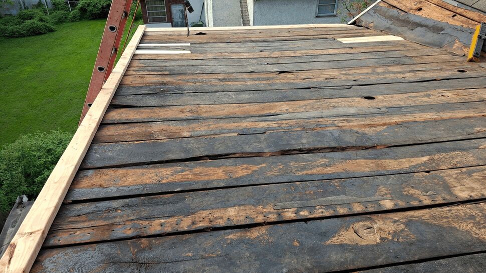 Exposed wooden roof decking boards with new lumber along the edge