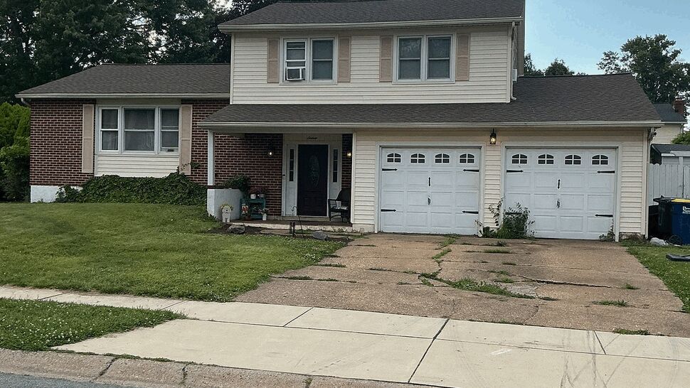 Two-story suburban house with beige siding, brick and attached double garage.