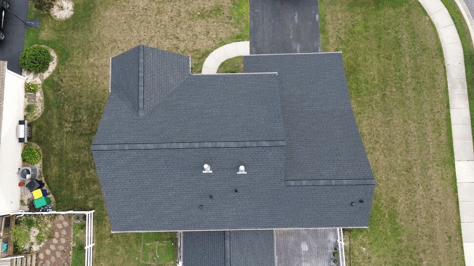 Top-down view of the home's entire dark shingle roof and surrounding yard.