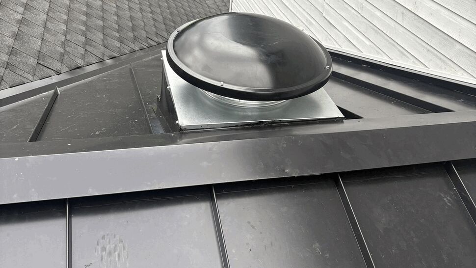 Round tubular skylight dome mounted on a black metal roof
