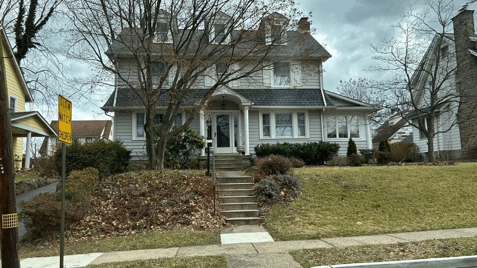 Two-story house with gray shingle roof and front steps