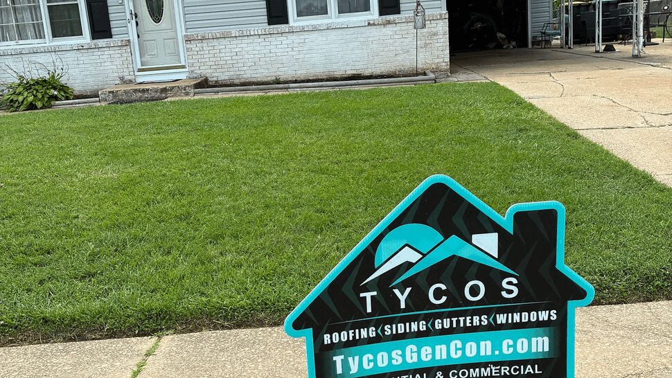 Yard sign for Tycos Roofing And Siding in front of a single-family house