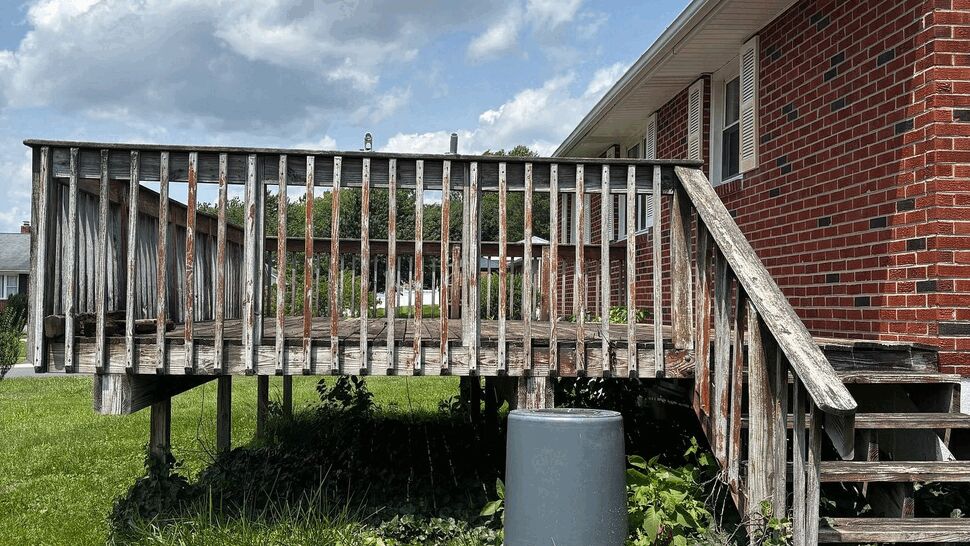 Weathered wooden back deck repair needed | Tycos Roofing And Siding Inc Weathered wooden back deck with stairs and railings in need of repair