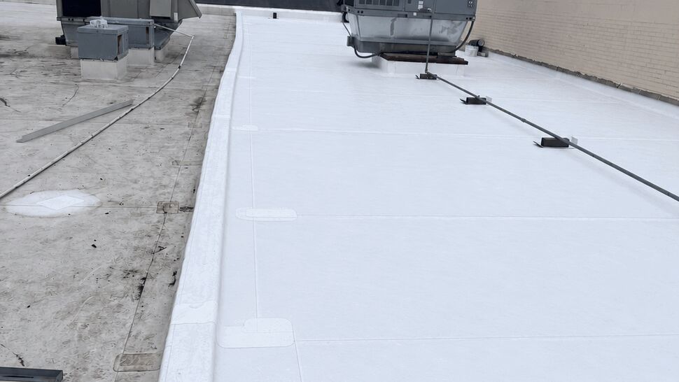 White commercial roof with HVAC | Tycos Roofing And Siding Inc White flat commercial roof with rooftop HVAC equipment.