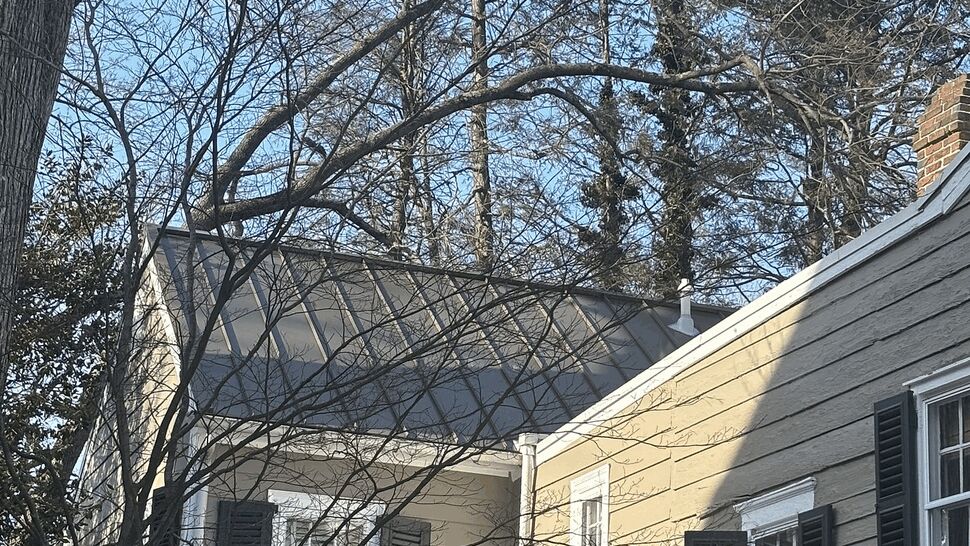 Winter House Roofing | Tycos Roofing And Siding Inc Side view of a historic home with snow-covered roofs and gray siding