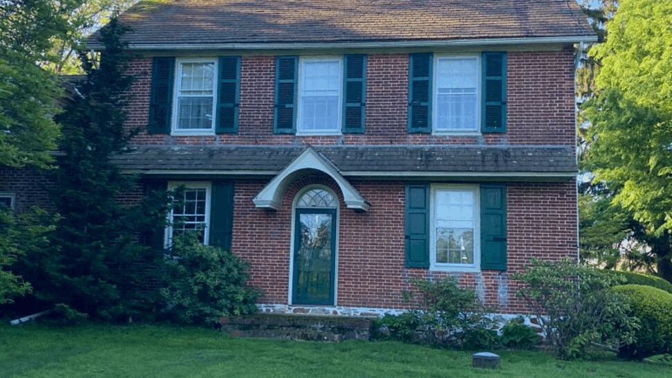 Storm Damage Roof Assessment | Tycos Roofing And Siding Inc Front elevation showing an older, weathered roof under clear skies