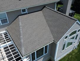 Close aerial of roof corner showing gutters, shingles and large windows
