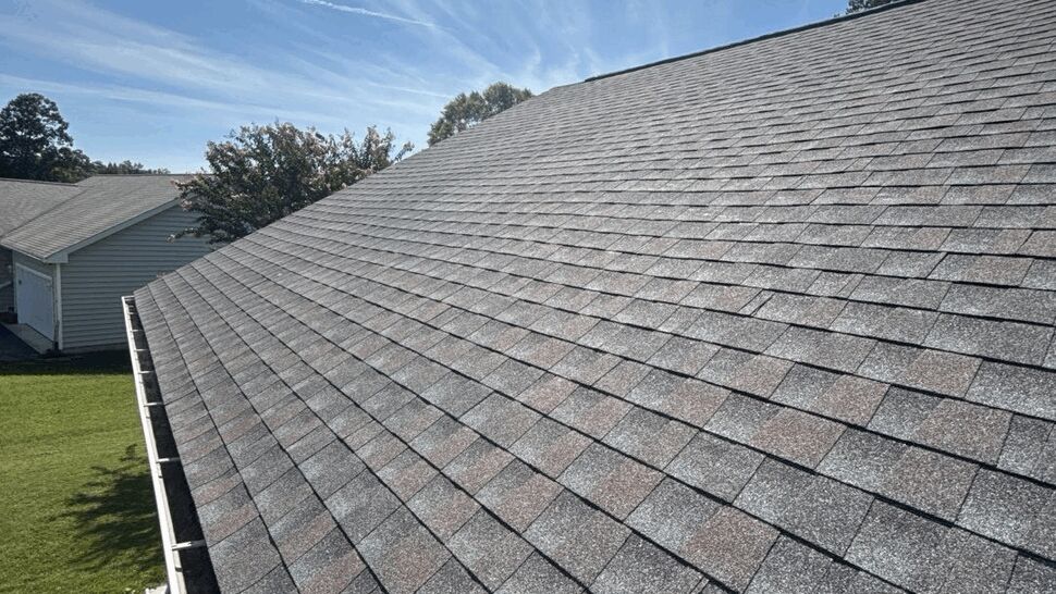 Gray Shingle Roof Overview | Top Roofing & Siding Gray asphalt shingle roof viewed from above under a blue sky