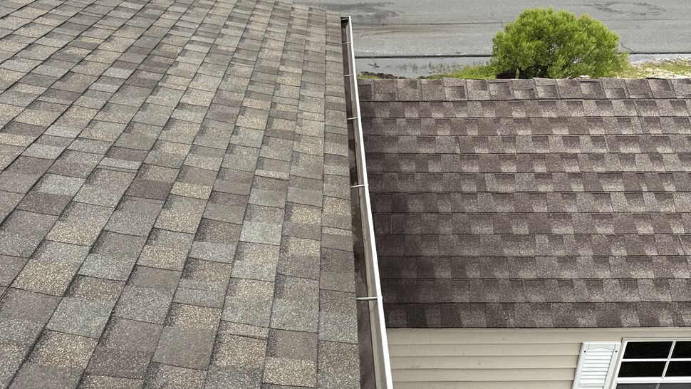 Roof and Gutter Edge | Top Roofing & Siding Gray shingle roof with a white gutter along the edge