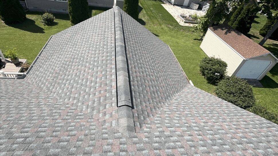 Roof Ridge Neighborhood View | Top Roofing & Siding Wide view of a shingle roof ridge above suburban homes and lawns