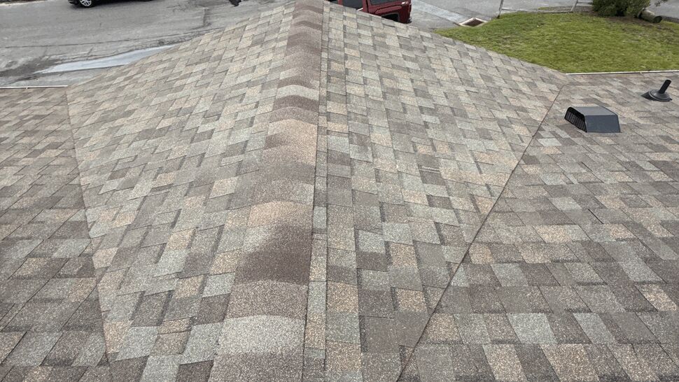 Roof Ridge Shingle Detail | Top Roofing & Siding Detailed view of gray shingles and a raised roof ridge
