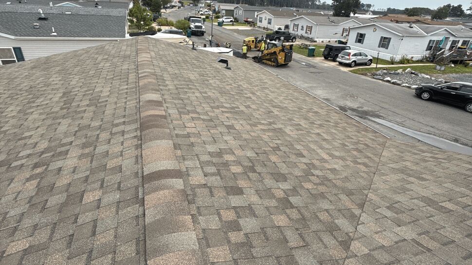 Roofing Worksite View | Top Roofing & Siding Gray shingle roof overlooking roofing equipment and nearby homes
