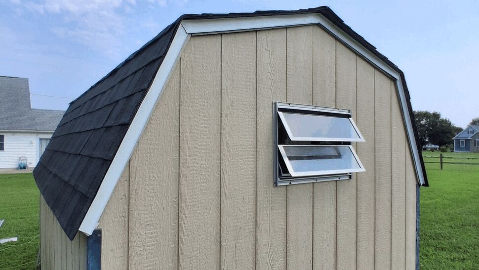 Finished Shed Roof and Windows | Top Roofing & Siding Tan shed with a dark shingle roof, white trim, and two windows.